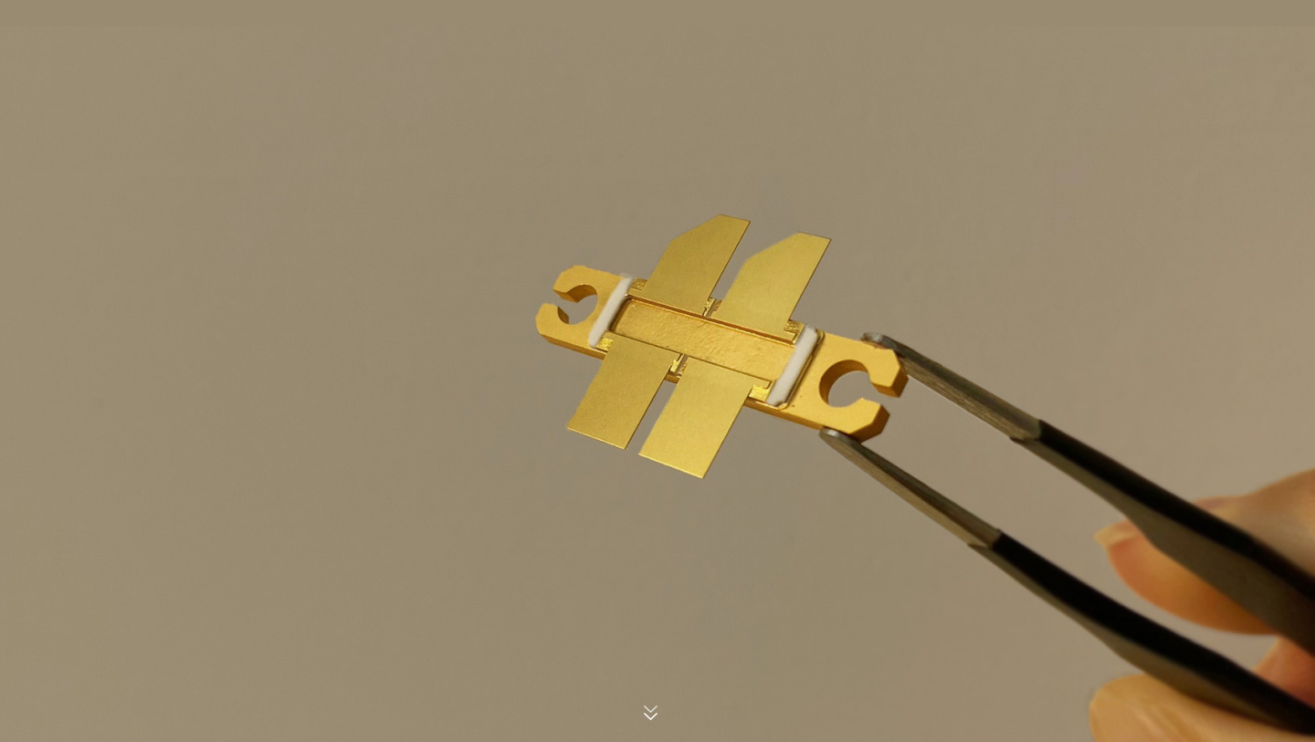 Gold semiconductor package held by precision tweezers